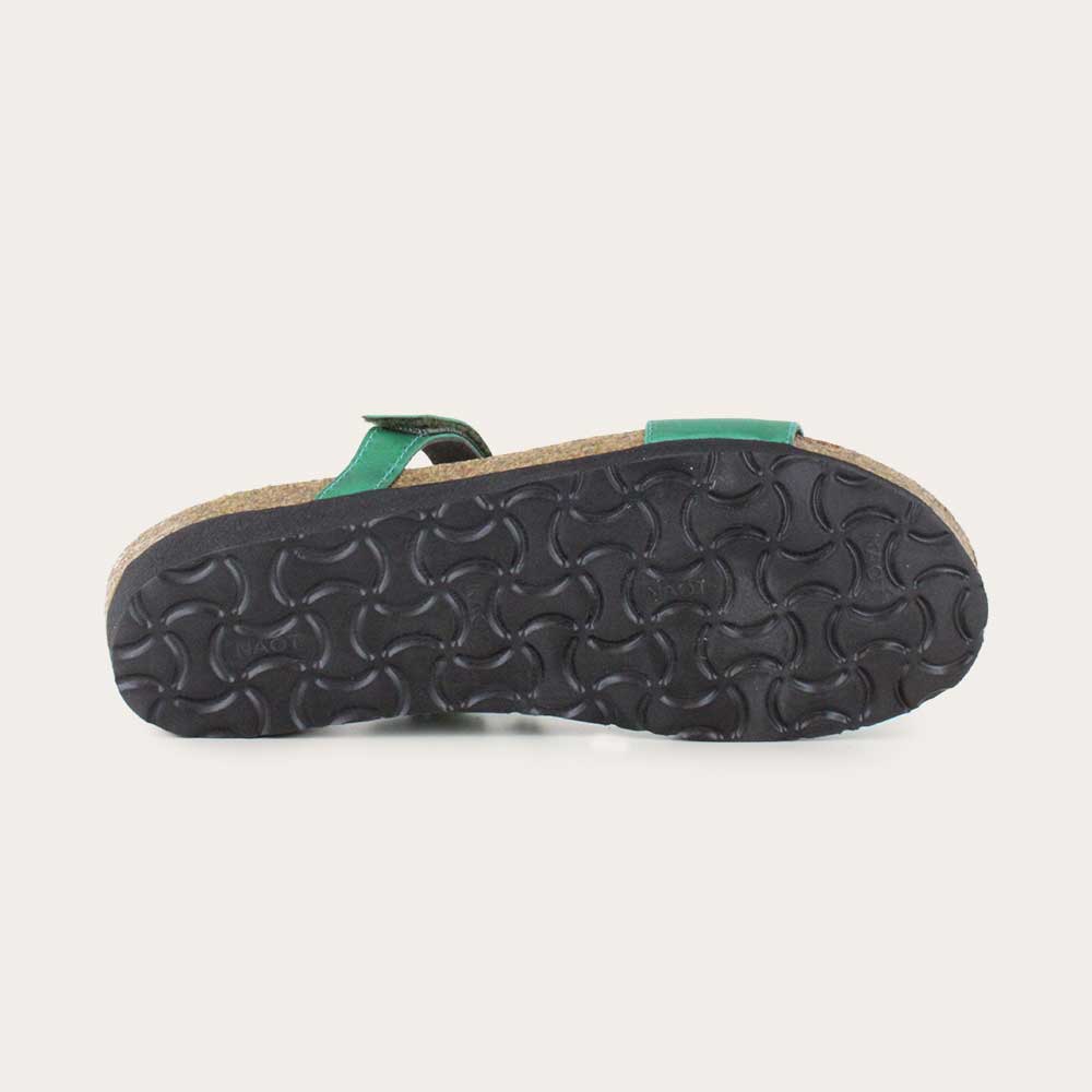 Bottom view of a green slip-on wedge sandal with a cork insole on a black sole.