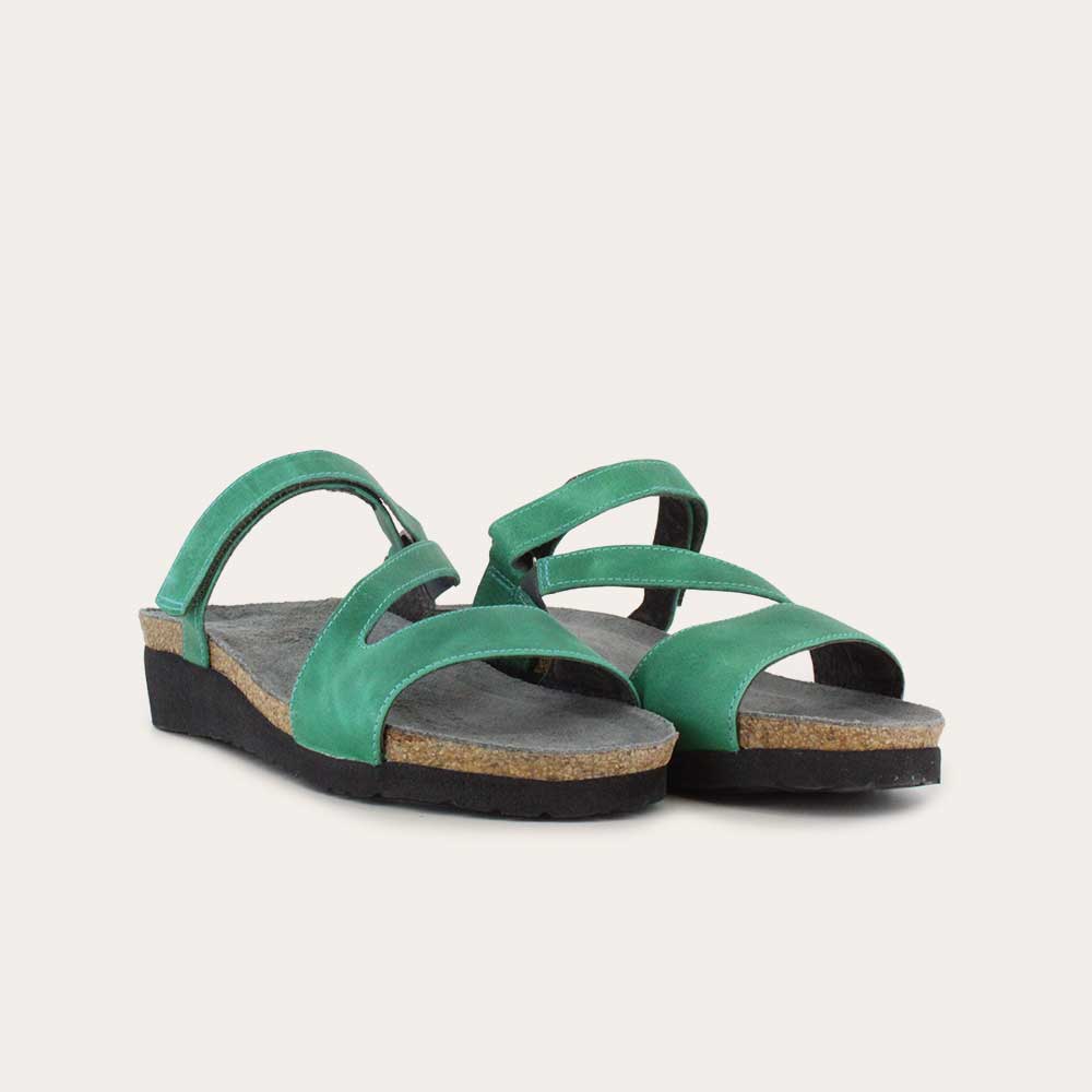 Pair of  green slip-on wedge sandals with a cork insole on a black sole.