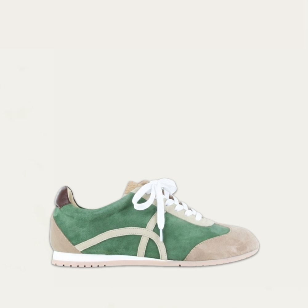 Profile view of a green suede sneaker with a swirl accent on the side on a low white and beige sole. 