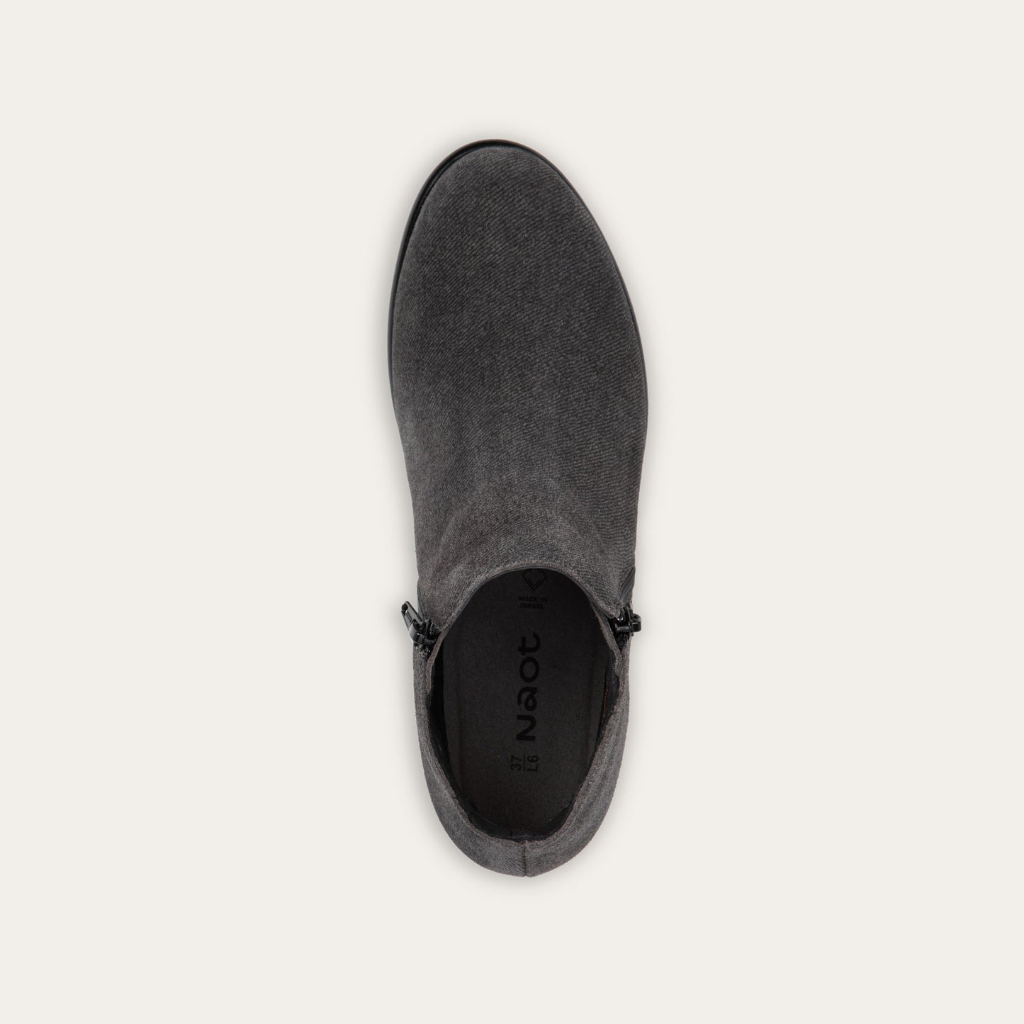 Top view of a black suede bootie on a black and brown sole.