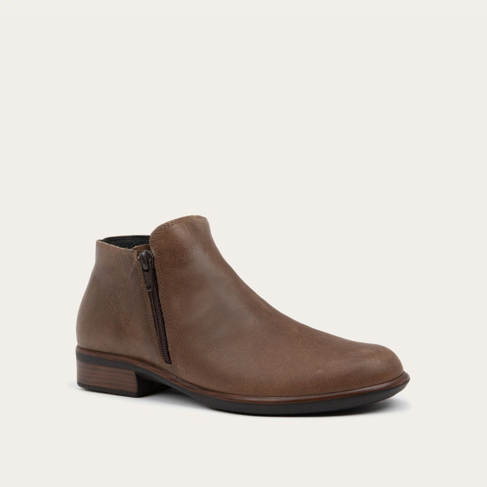 Angled  view of a brown bootie with a black and brown sole.