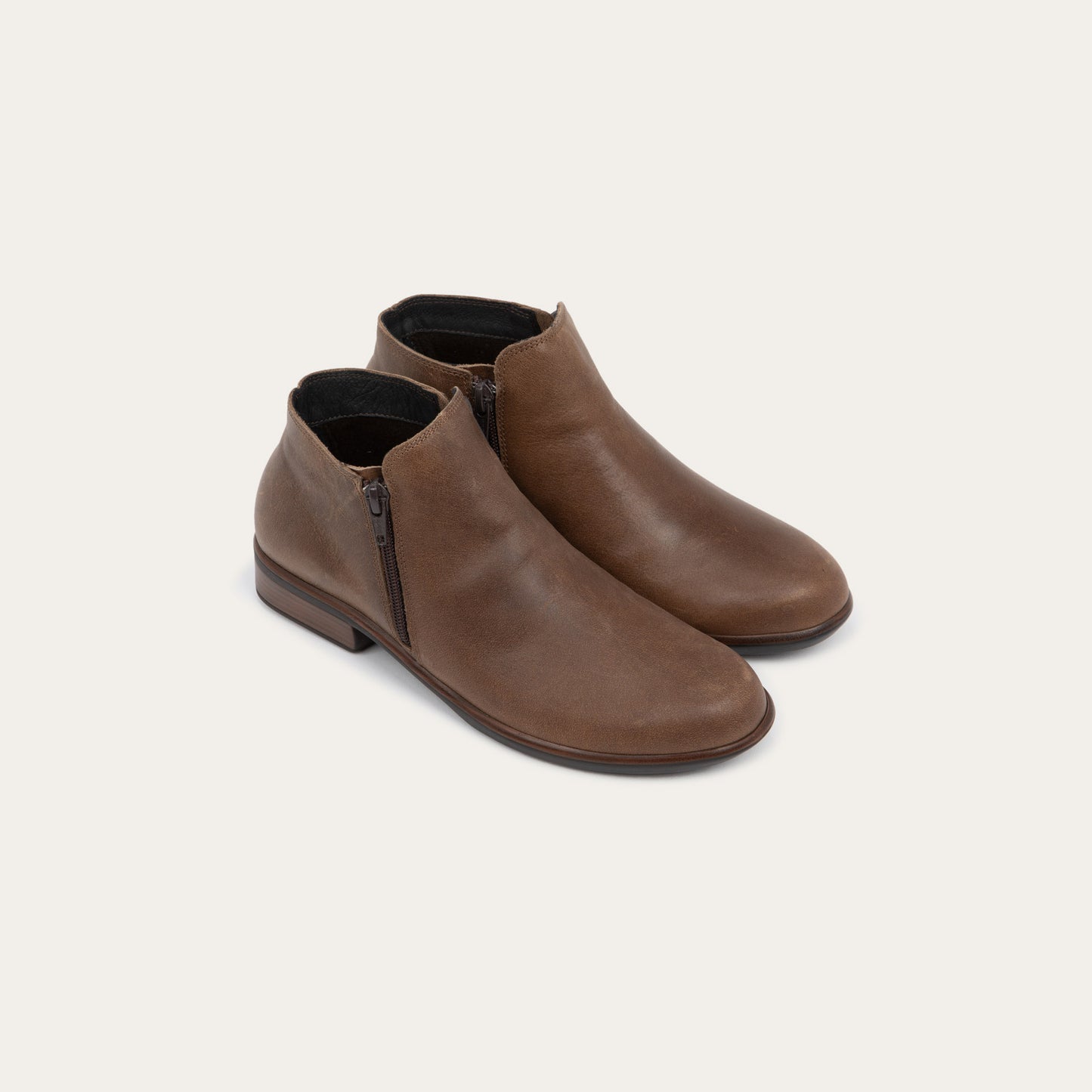 A pair of a brown booties with a black and brown sole.