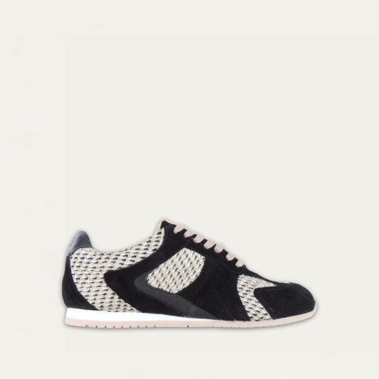 Profile view of a black suede sneaker with raffia on a low white and beige sole. 