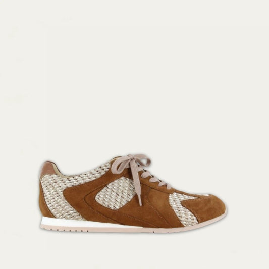 Profile view of a brown suede sneaker with raffia on a low white and beige sole. 