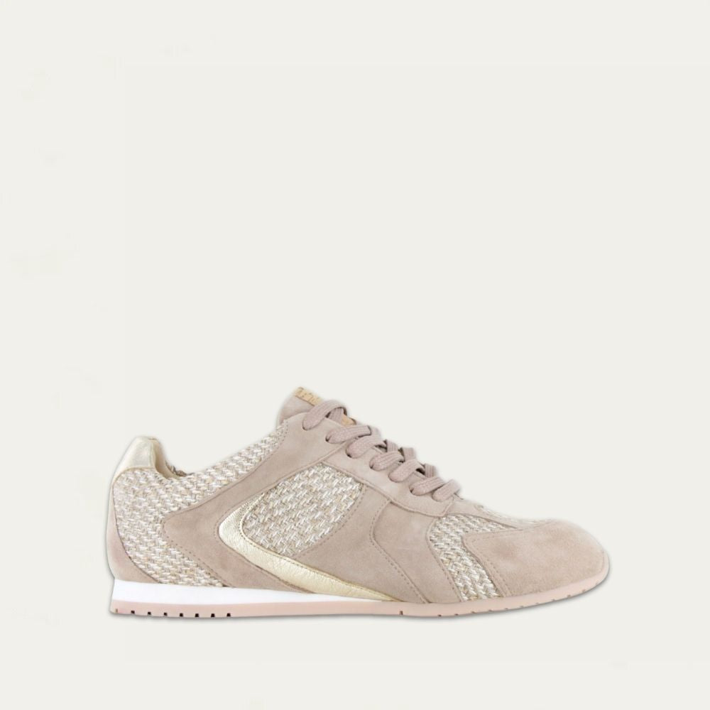 Profile view of a gold suede sneaker with raffia on a low white and beige sole. 