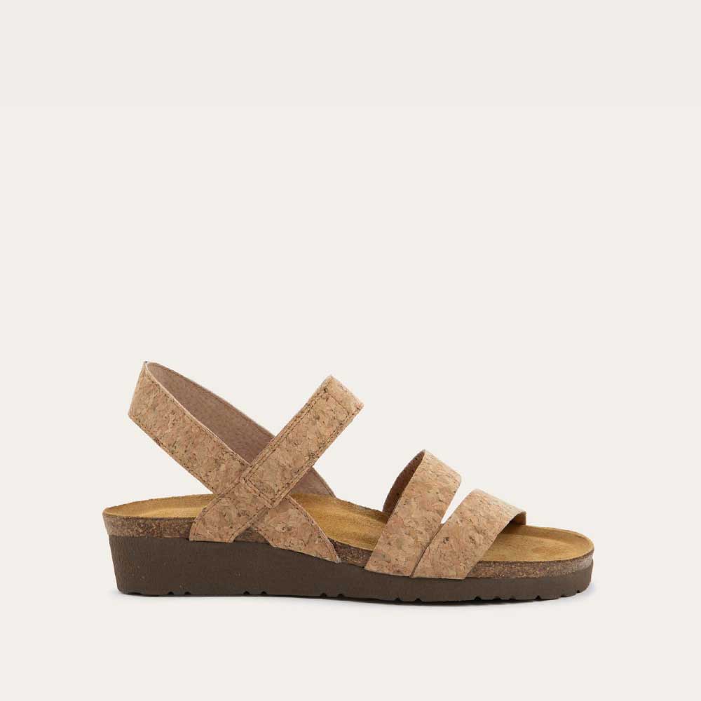 Profile view of cork-leather sandal with a cork footbed, black sole, and triple-strap design including a crisscross ankle strap.