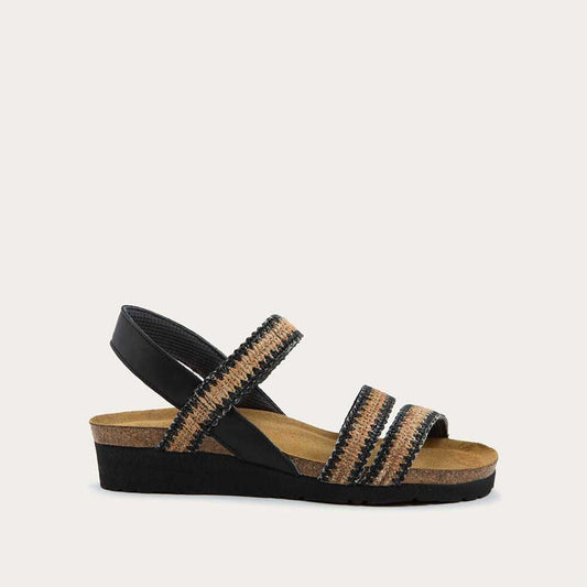 Profile view of a black printed, multi-strap, sling-back sandal with a cork footbed.