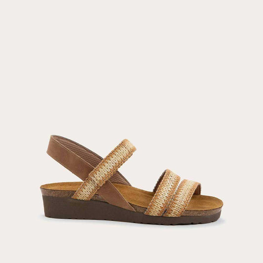 Profile view of brown and ivory raffia sandal with a cork footbed, black sole, and triple-strap design including a crisscross ankle strap.
