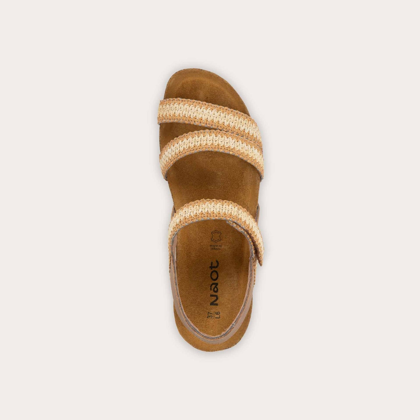 Top view of  brown and ivory raffia sandal with a cork footbed, black sole, and triple-strap design including a crisscross ankle strap.