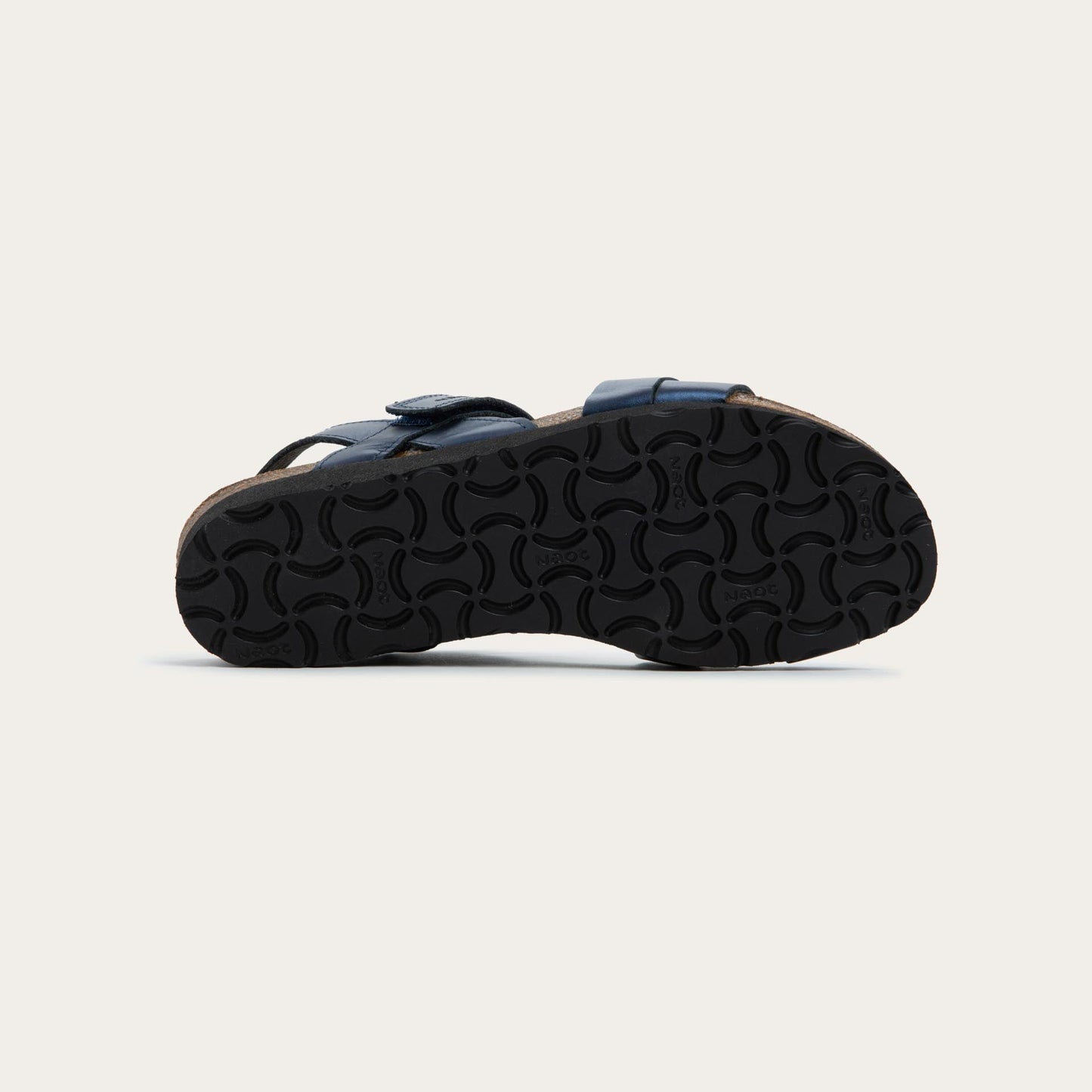 Bottom view of a navy blue sandal with a cork footbed, black sole, and triple-strap design including a crisscross ankle strap.