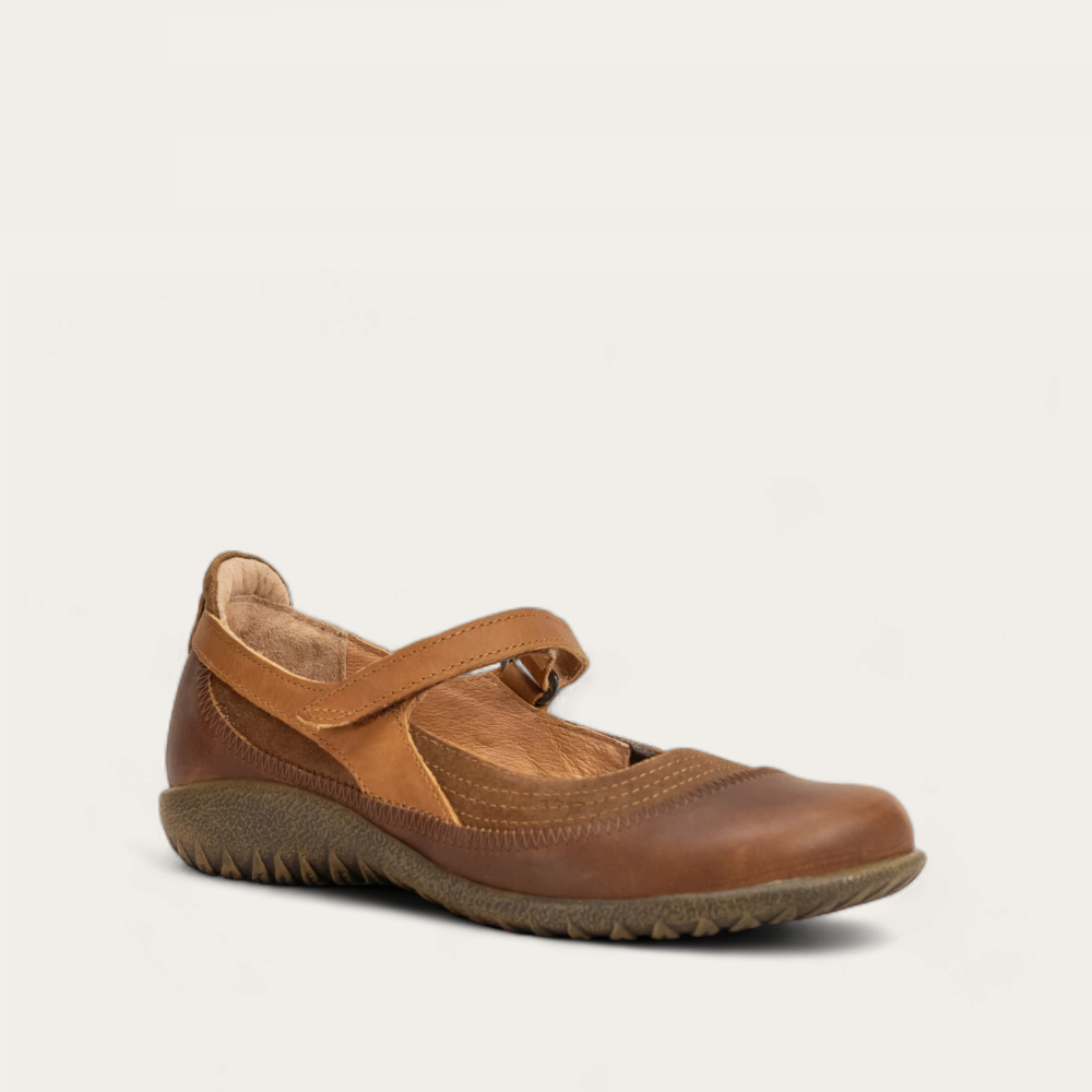 Angled profile view of a brown leather Mary Jane shoe with a hook-and-loop strap
