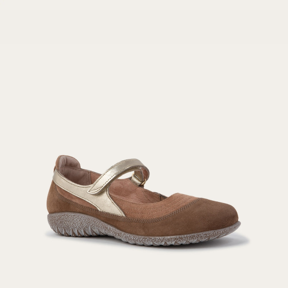 Angled view of a brown Mary Jane flat with metallic strap, suede upper, and textured sole.