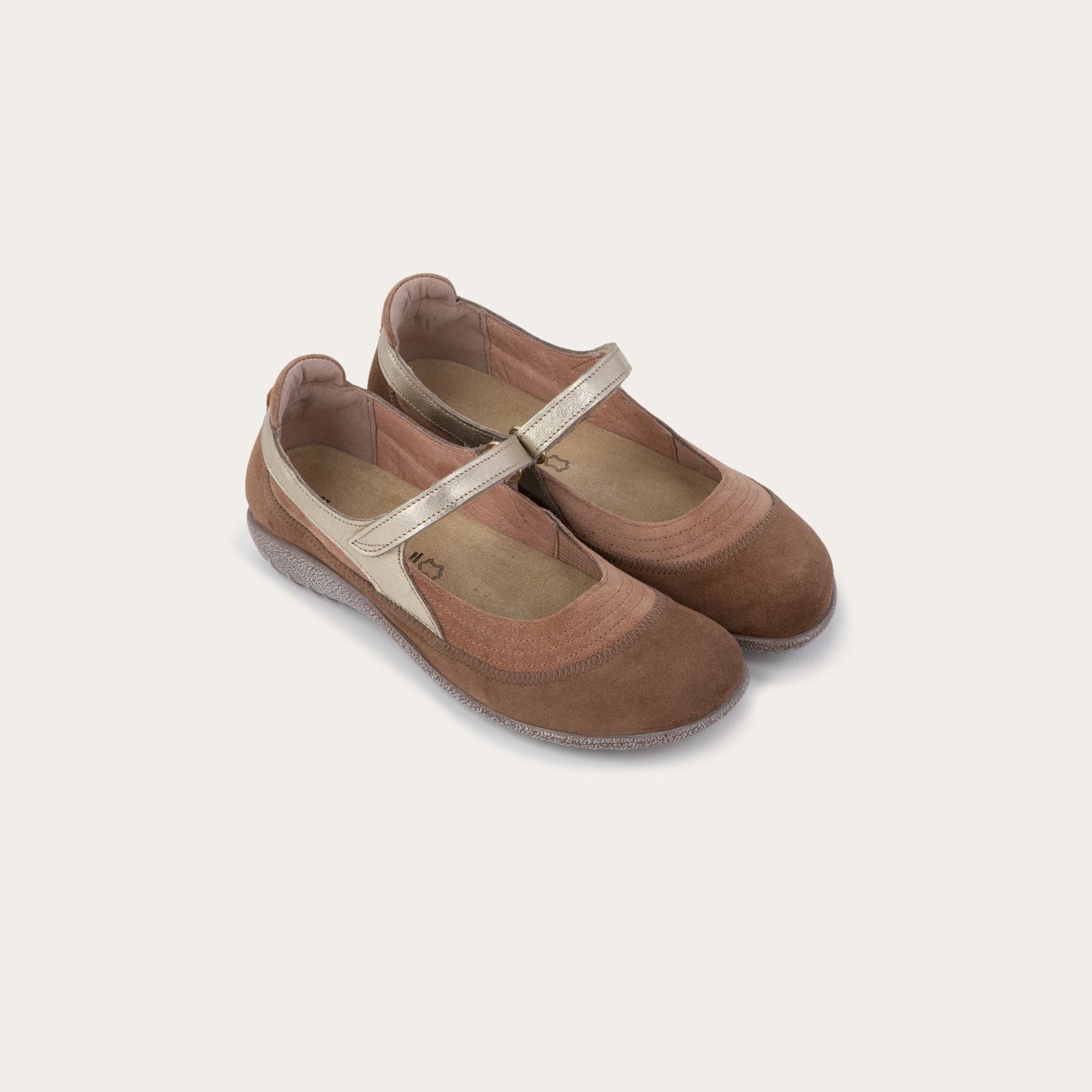 Pair of brown Mary Jane flats with metallic straps, suede uppers and textured soles.