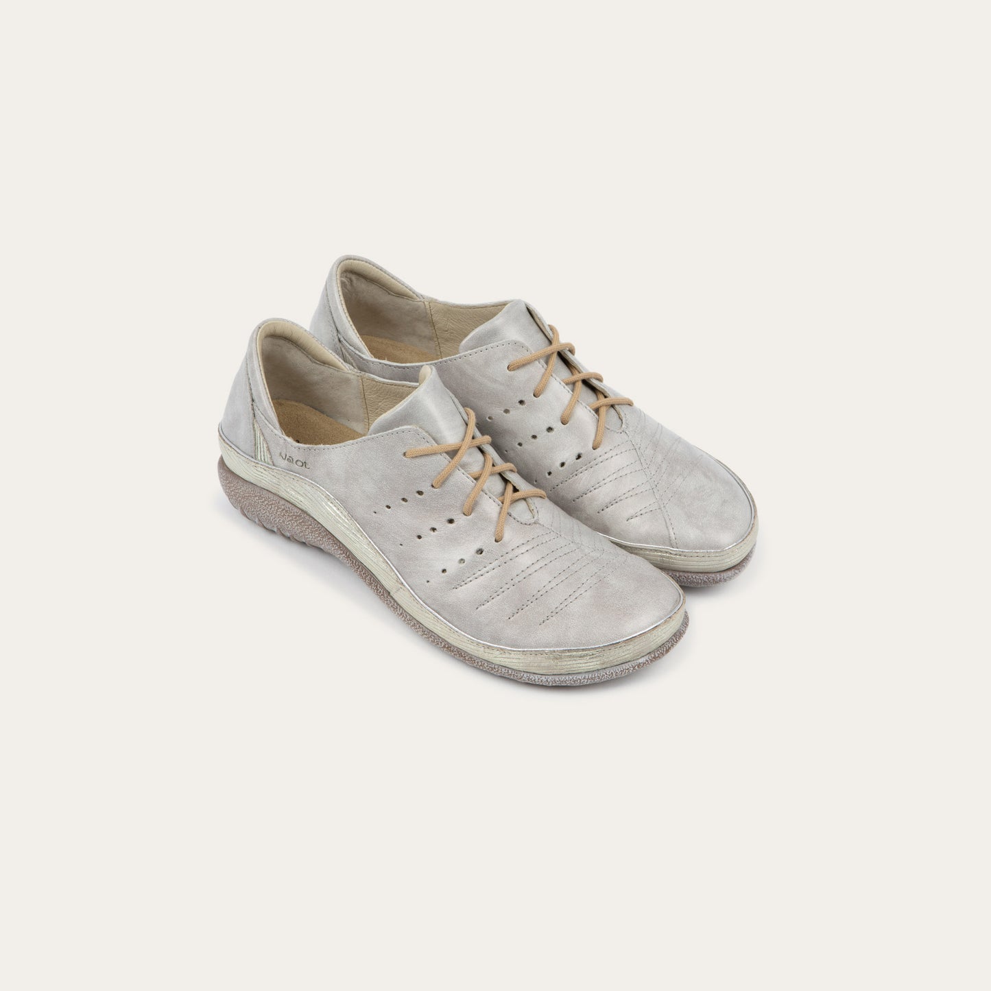Pair of casual beige lace-up shoes with textured sole and side perforations.