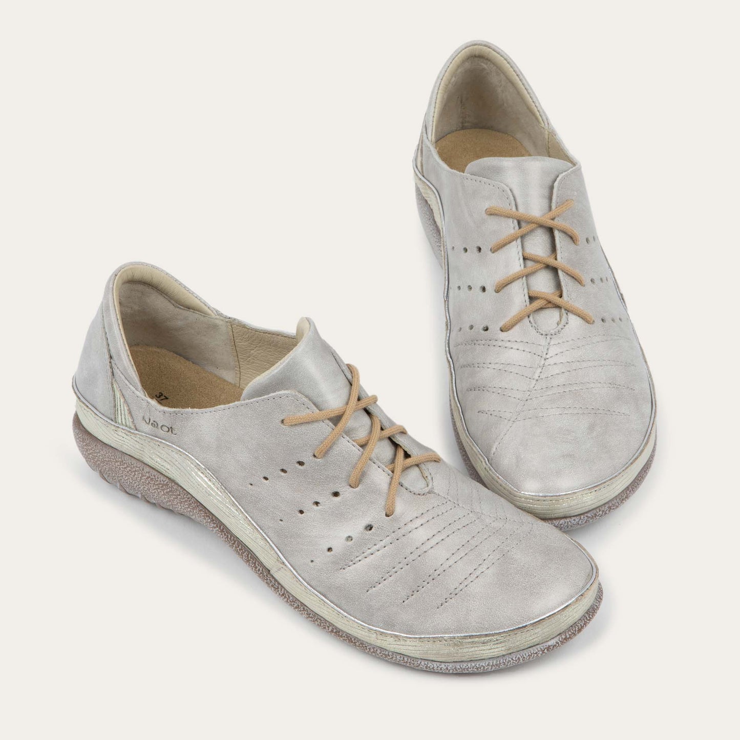 Pair of casual beige lace-up shoes with textured sole and side perforations.