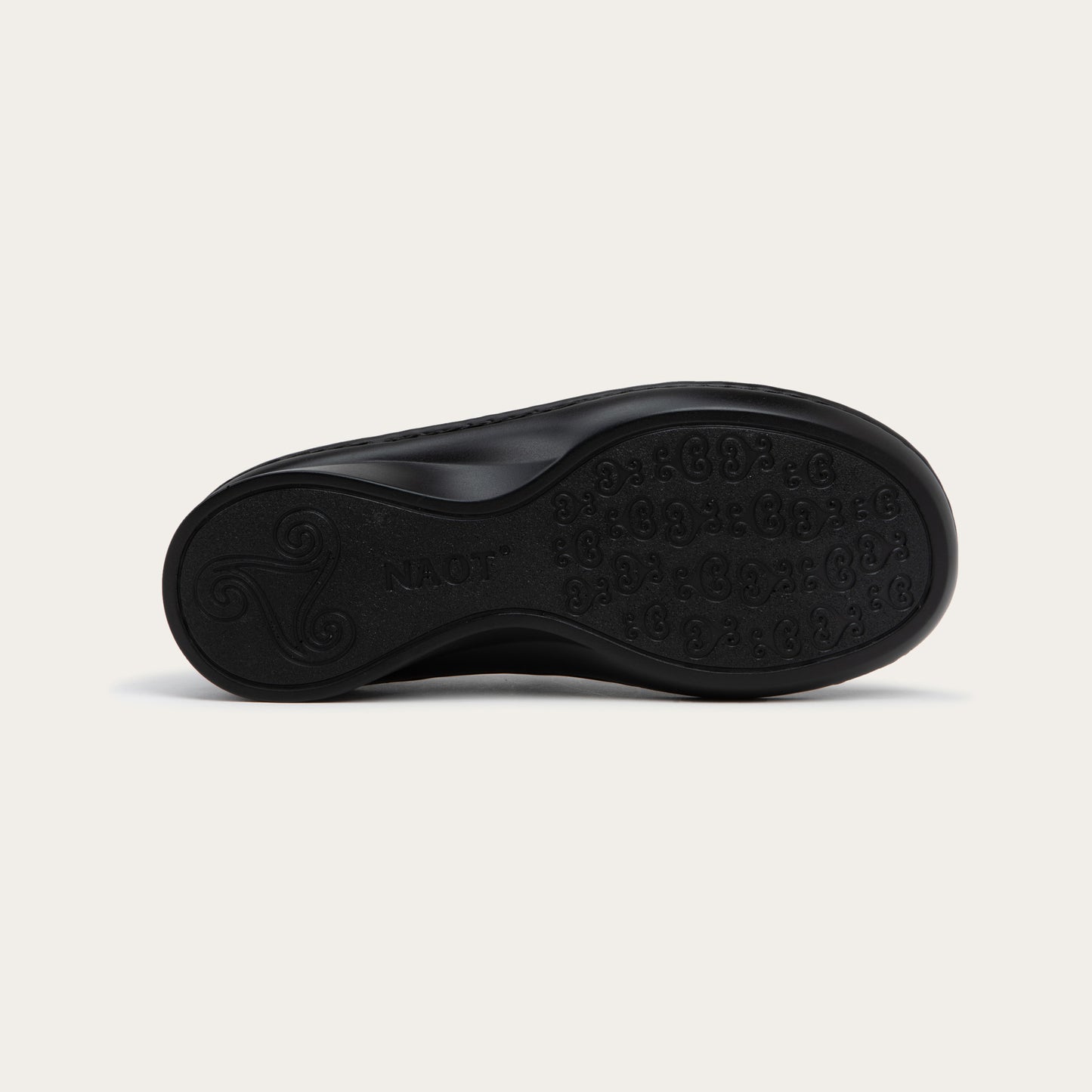 Bottom view of a black maryjane on a black sole featuring a simple buckle and small cutout detail on the side