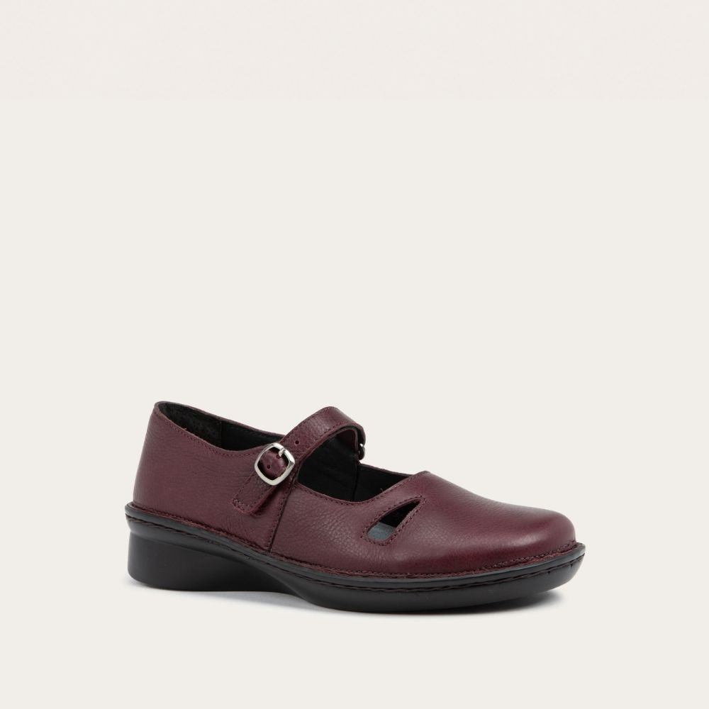 Pair of  red maryjanes on a black sole featuring a simple buckle and small cutout detail on the side