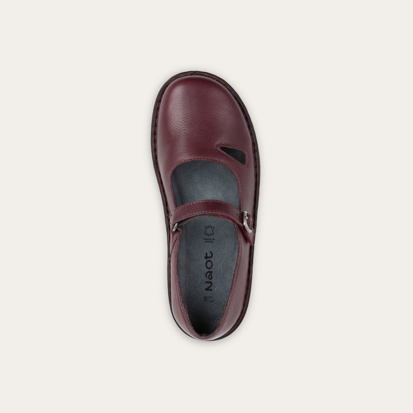 Top view of a red maryjane on a black sole featuring a simple buckle and small cutout detail on the side