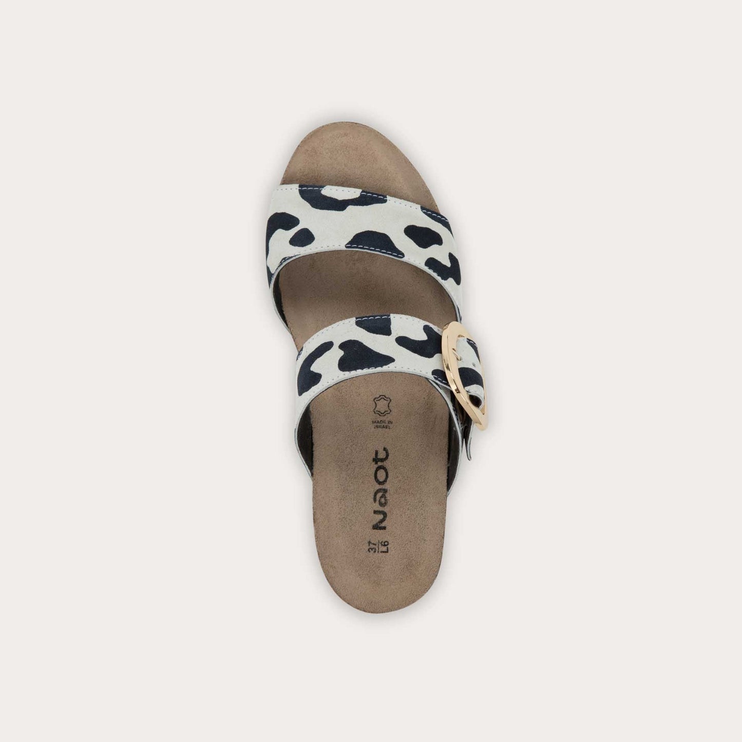 Top view of a black and white leaopard-print slip on wedge sandal with two straps and a large gold buckle. 