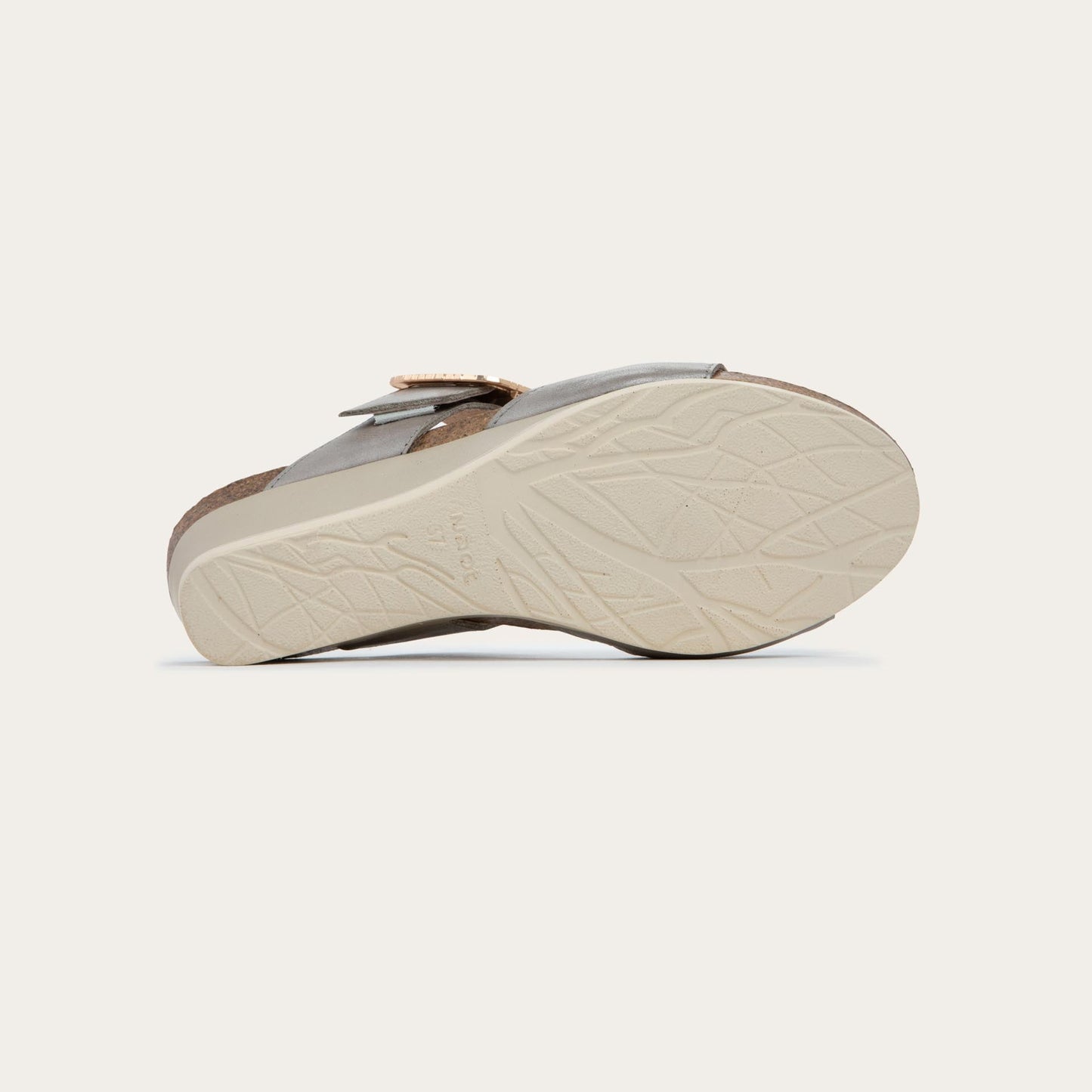 Bottom view of a metalic gray slip-on wedge sandal with two straps and a large textured buckle.  