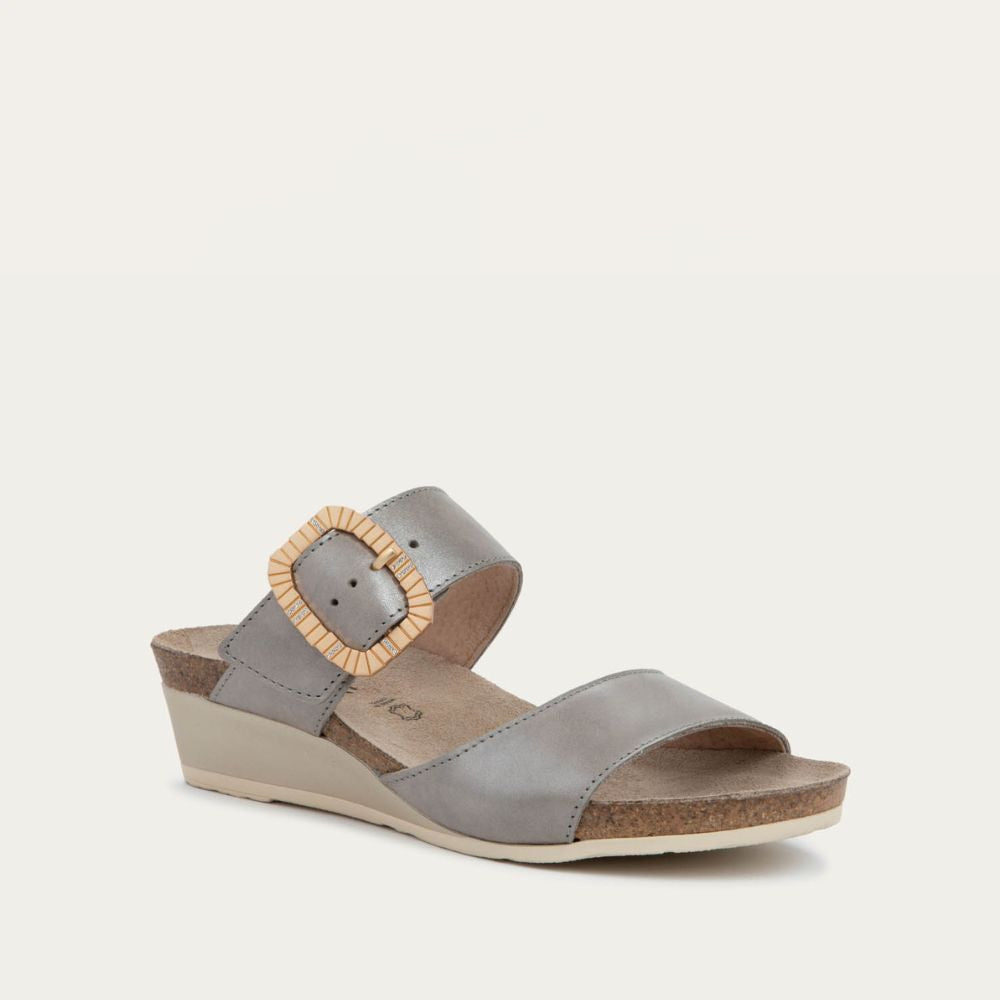 Angled profile view of a metali gray slip-on wedge sandal with two straps and a large textured buckle. 