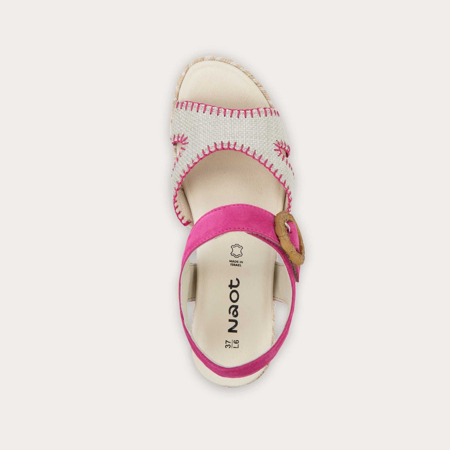 Top view of a beige/pink wedge sandal with a woven platform and pink suede ankle strap, fastened by a circular buckle. 