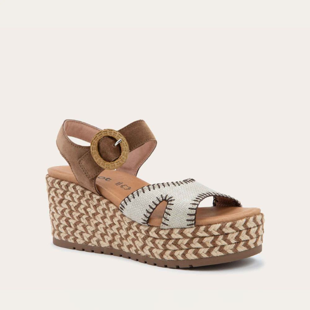Angled profile view of a beige/brown wedge sandal with a woven platform and brown suede ankle strap, fastened by a circular buckle. 