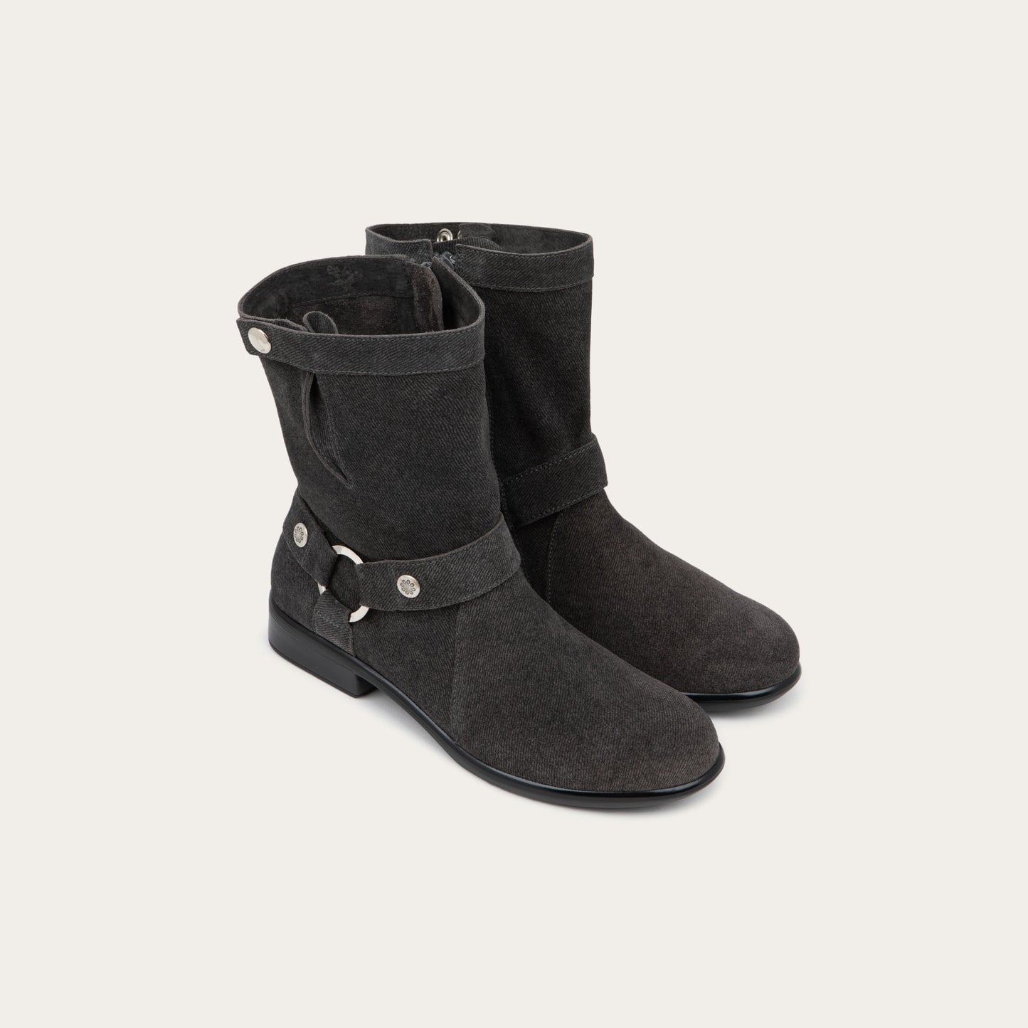 Pair of black suede mid-calf boots with decorative t-strap and buckle, side zipper, rounded toe, and low stacked heel