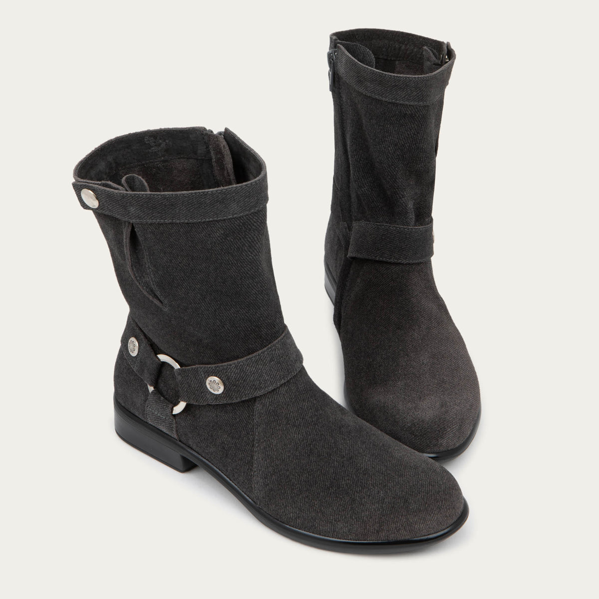 Pair of black suede mid-calf boots with decorative t-strap and buckle, side zipper, rounded toe, and low stacked heel