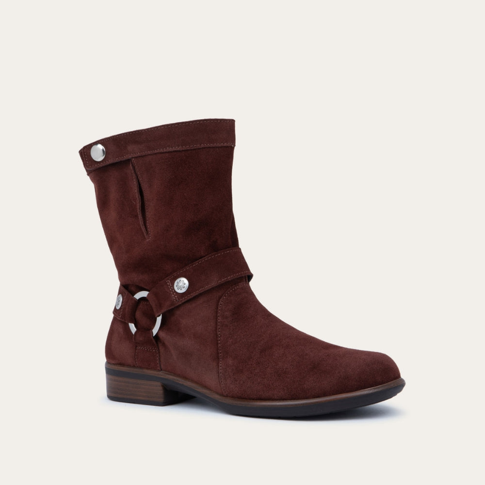 Angled profile view of a violet suede mid-calf boot with decorative t-strap and buckle, side zipper, rounded toe, and low stacked heel