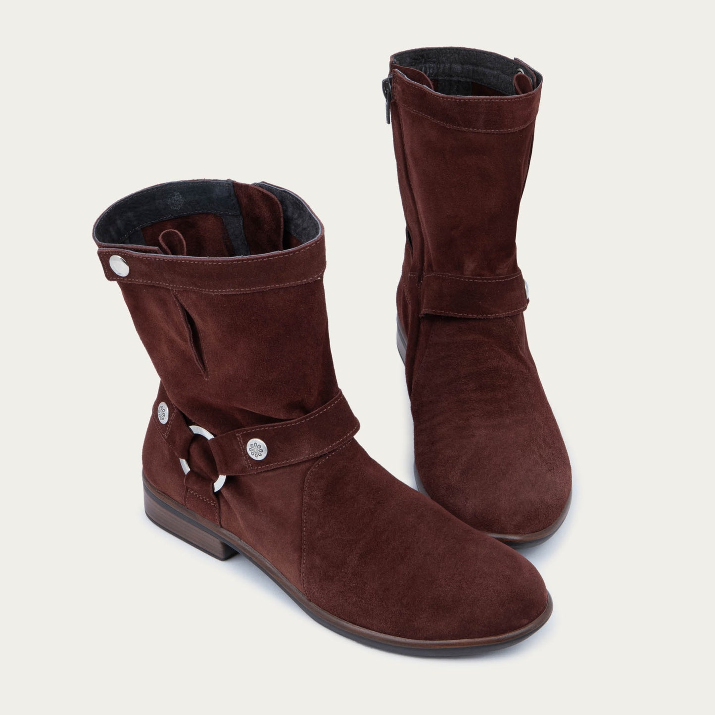 Pair of violet suede mid-calf boots with decorative t-strap and buckle, side zipper, rounded toe, and low stacked heel
