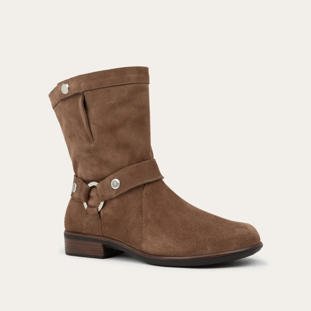 Angled profile view of a brown suede mid-calf boot with decorative t-strap and buckle, side zipper, rounded toe, and low stacked heel