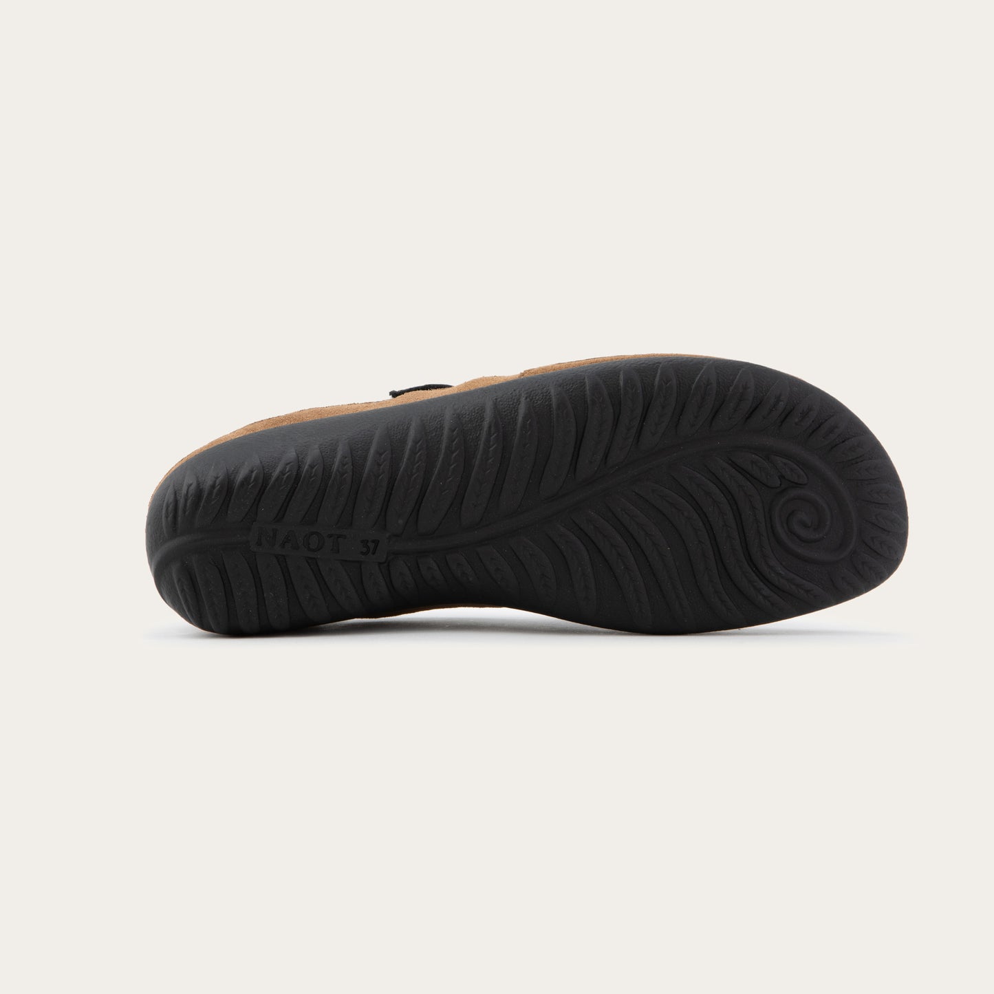 Bottom view of a brown and black Mary Jane on a textured sole.