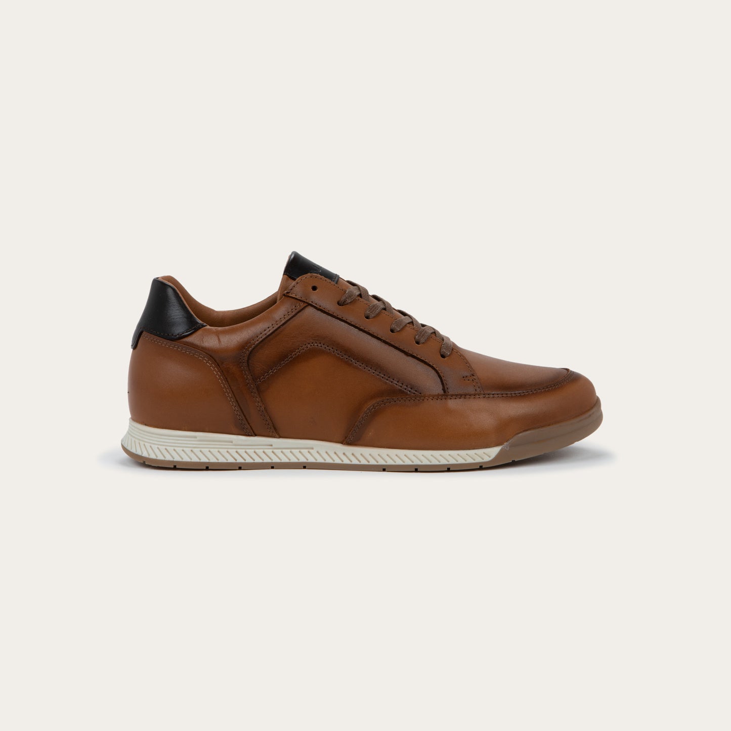 Profile view of a brown sneaker on a brown sole.