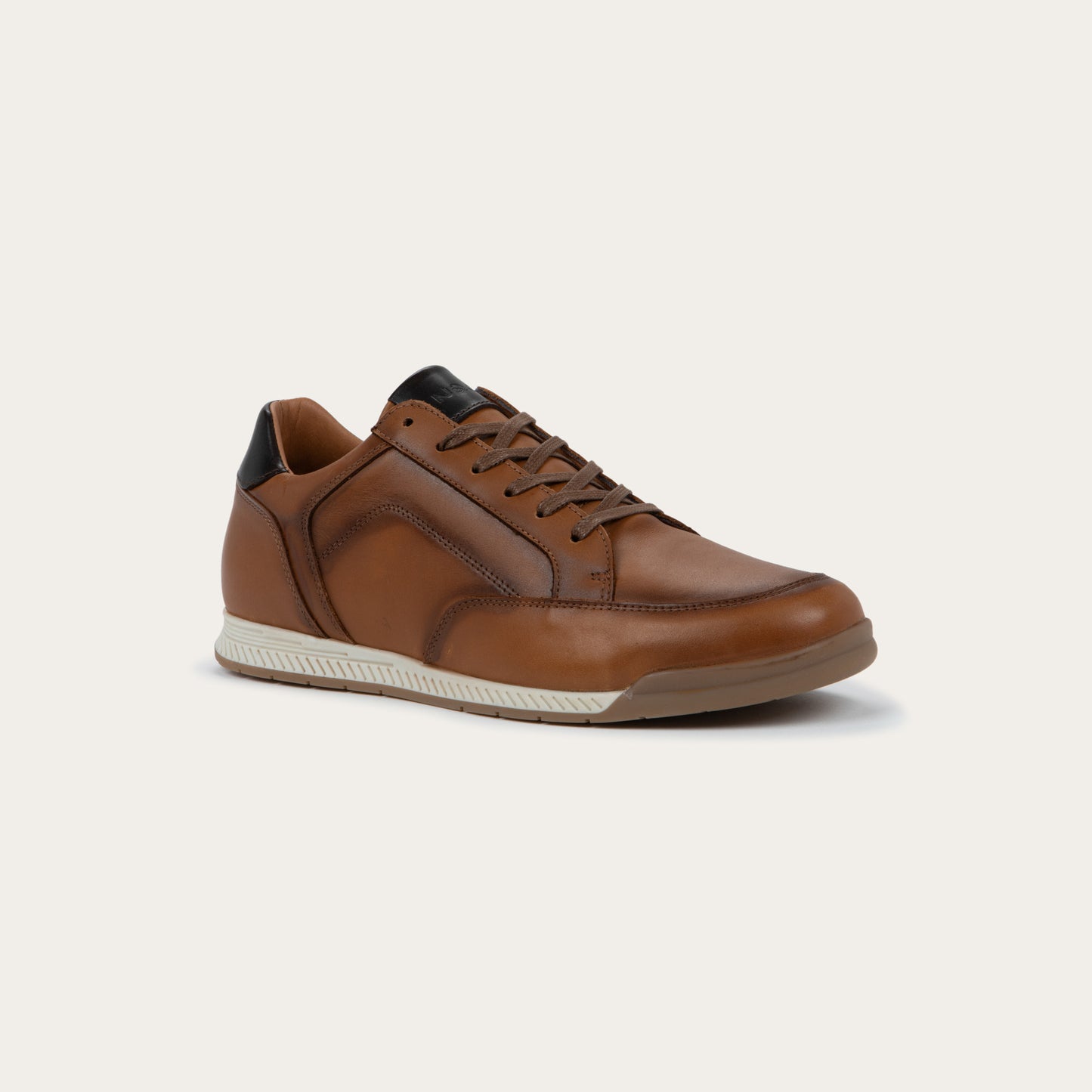 Angled profile view of abrown sneaker on a brown sole.