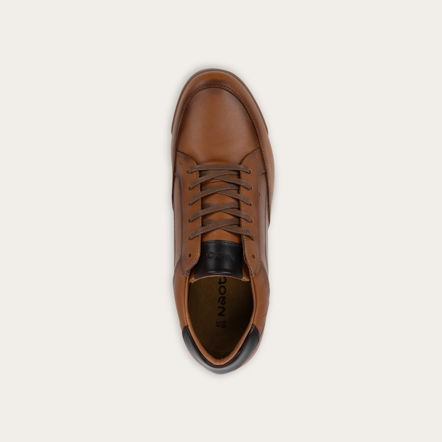 Top view of a brown sneaker on a brown sole.