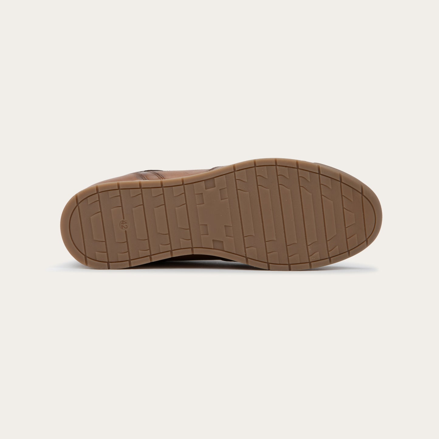Bottom view of a brown sneaker on a brown sole.