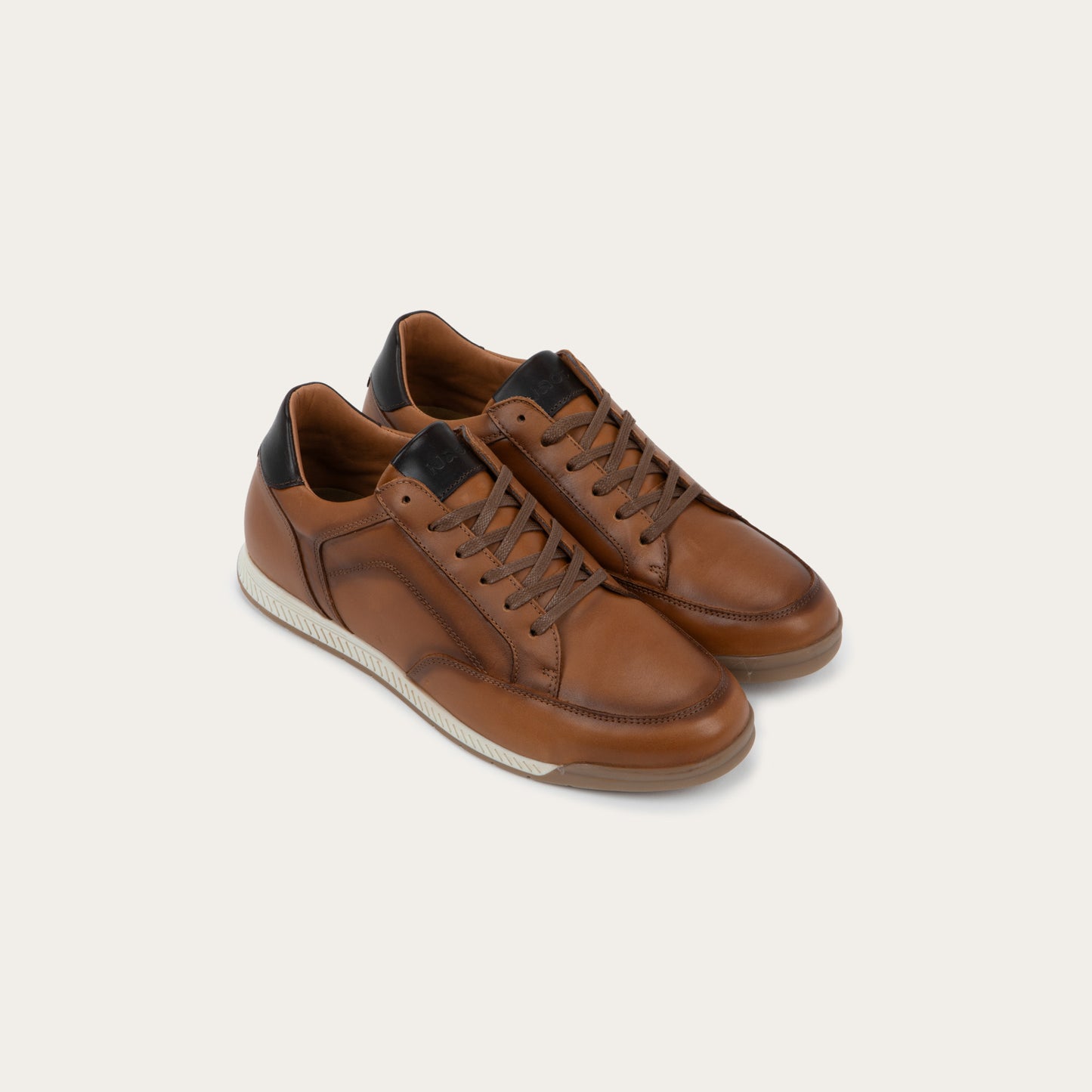 Pair of brown sneaker on a brown sole.