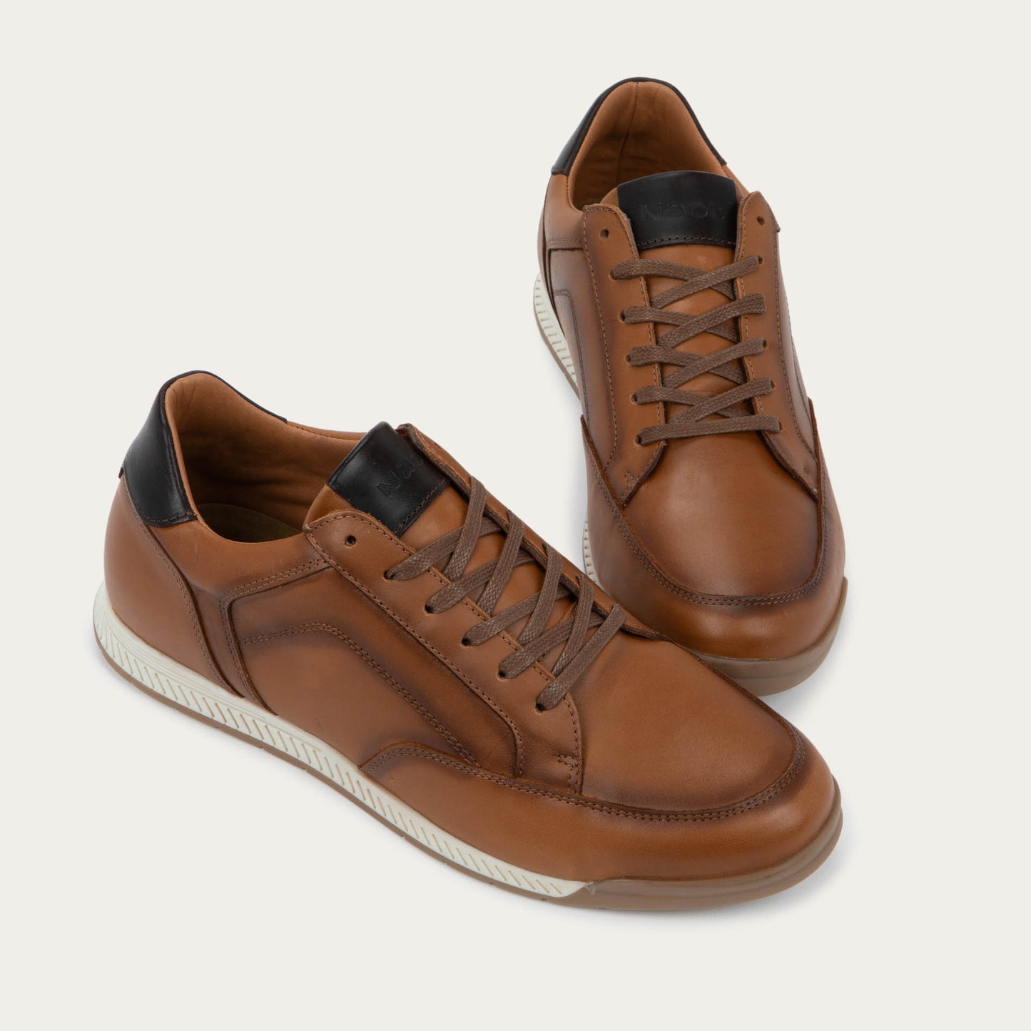 Pair of brown sneaker on a brown sole.