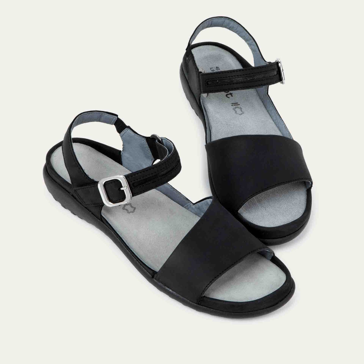 Pair of  black, open toe sandals, featuring a toe strap and asjustable ankle strap with a silver accent buckle.