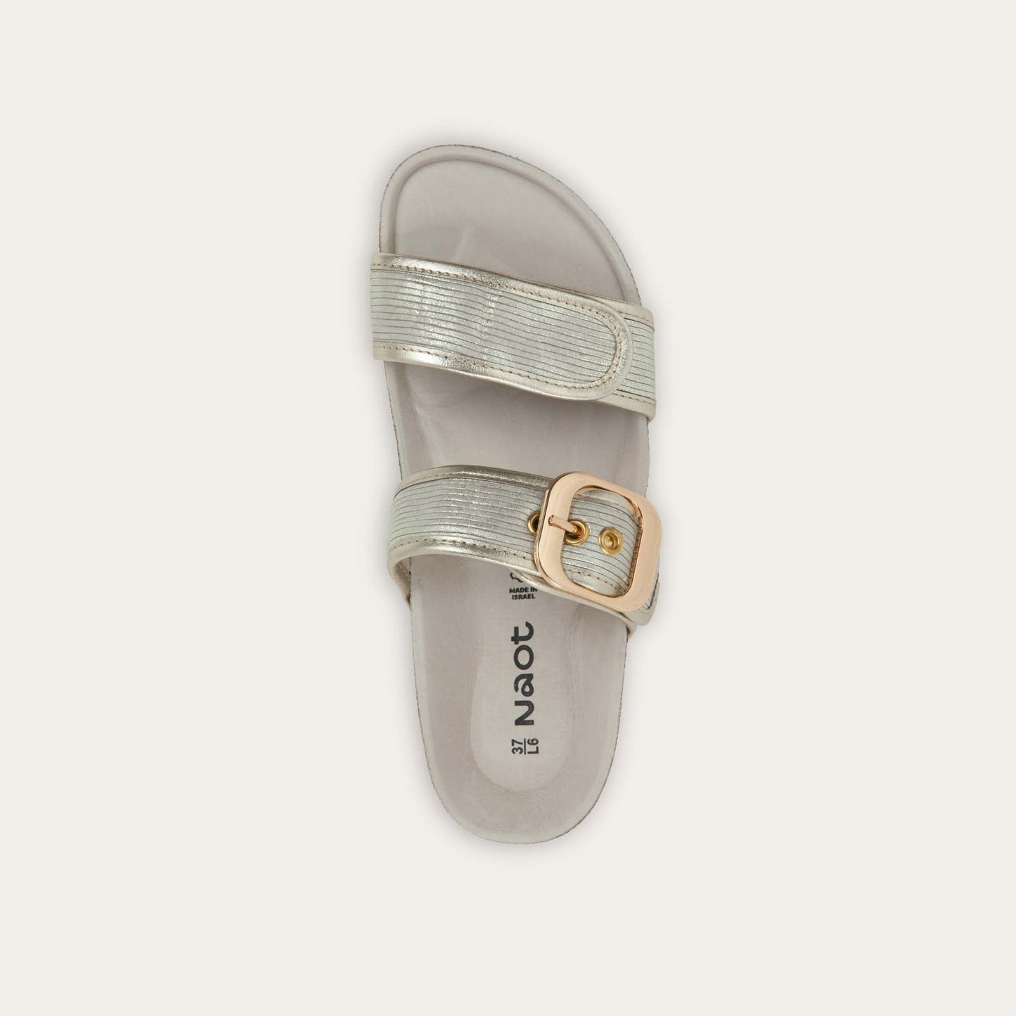 Top view of a metalic beige slide with two adjustable straps featuring gold buckles,  cork footbed and, white sole
