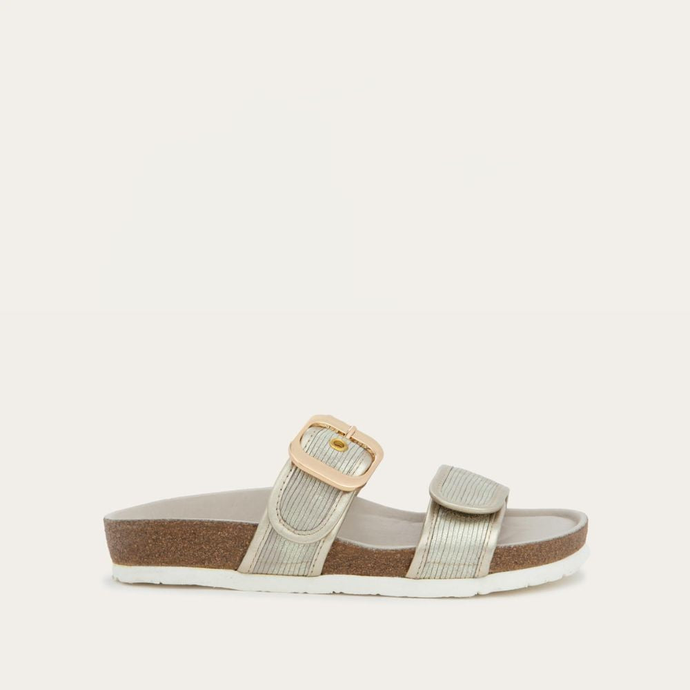 Profile view of a metalic beige slide with two adjustable straps featuring gold buckles,  cork footbed and, white sole
