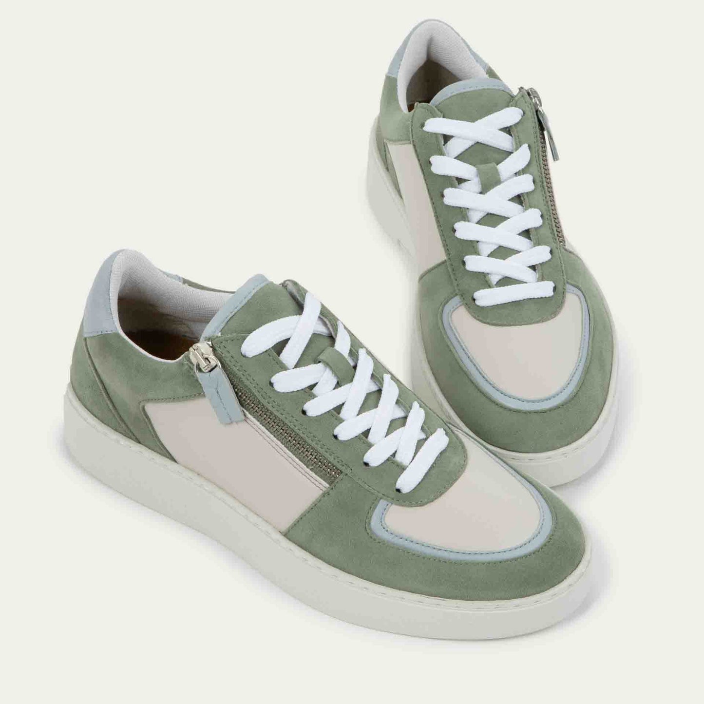 Pair of multicolored green and white sneakers with laces and a side zipper.