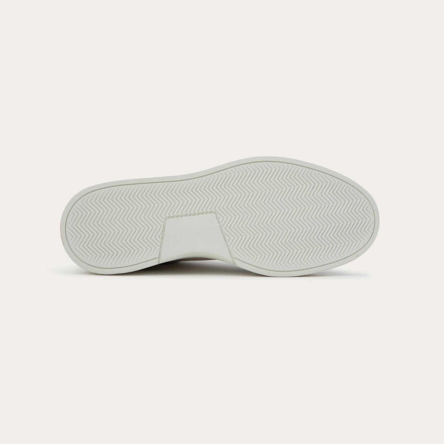 Bottom view of a multicolored white, beige, and black sneaker with laces and a side zipper.