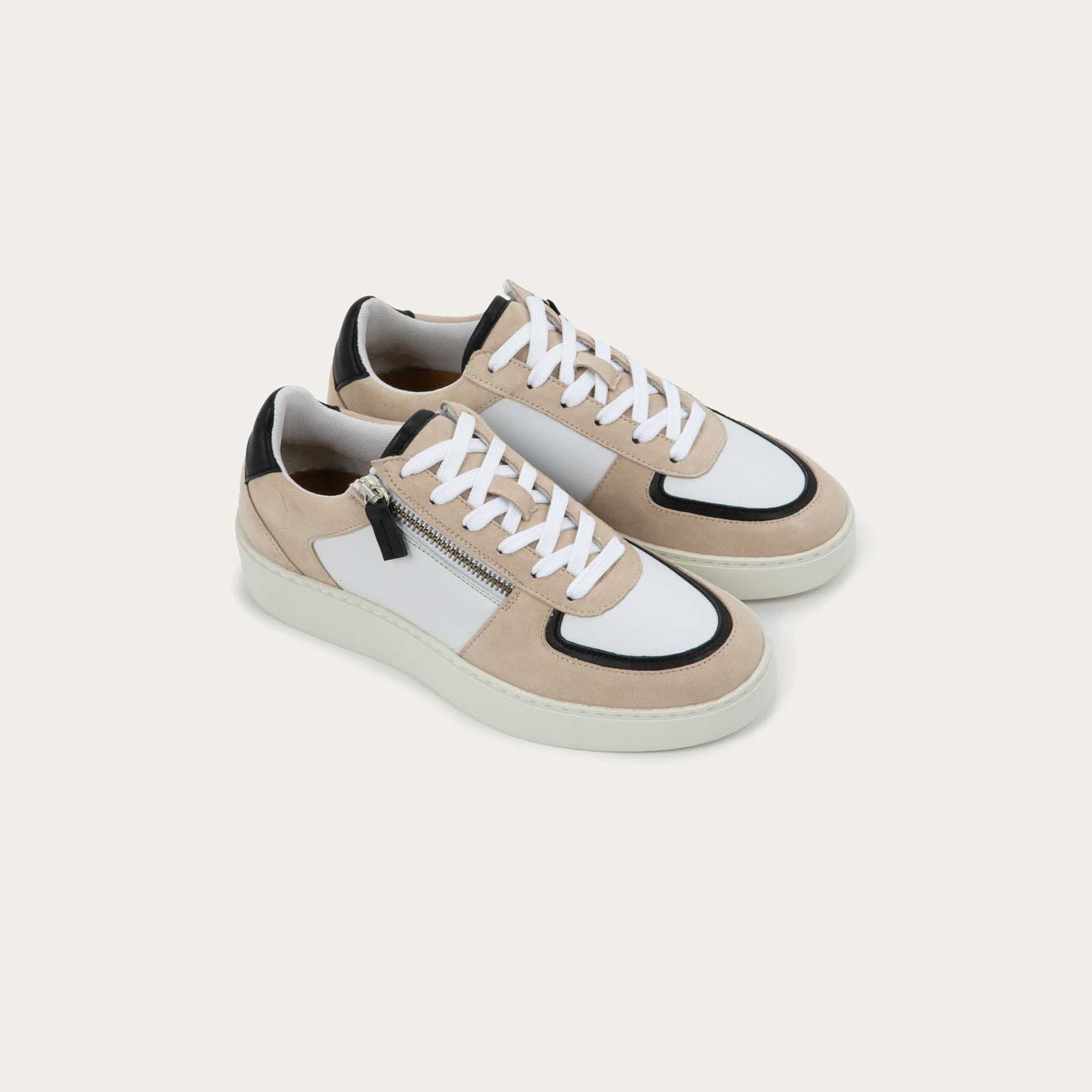 Pair of multicolored white, beige, and black sneakers with laces and a side zipper.