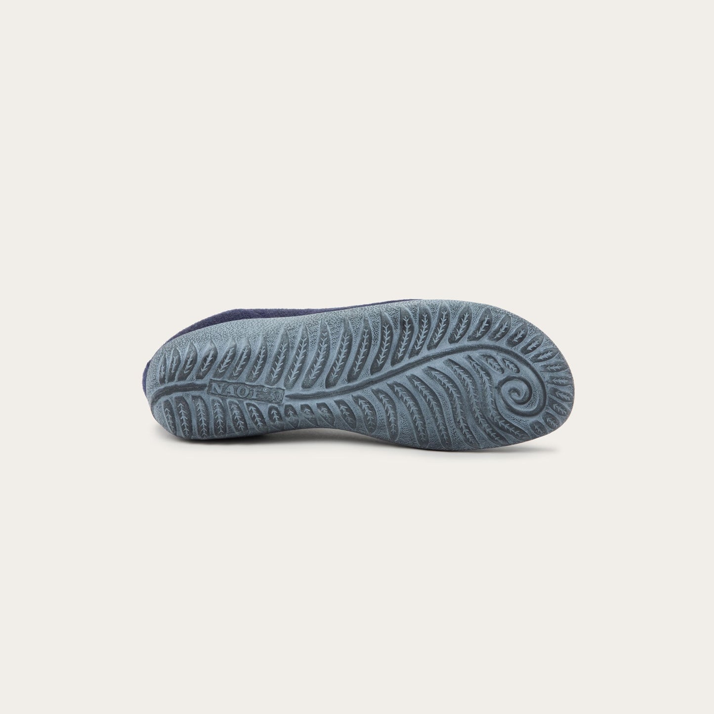 Bottom of a grey sole on a navy knit slip-on vegan shoe