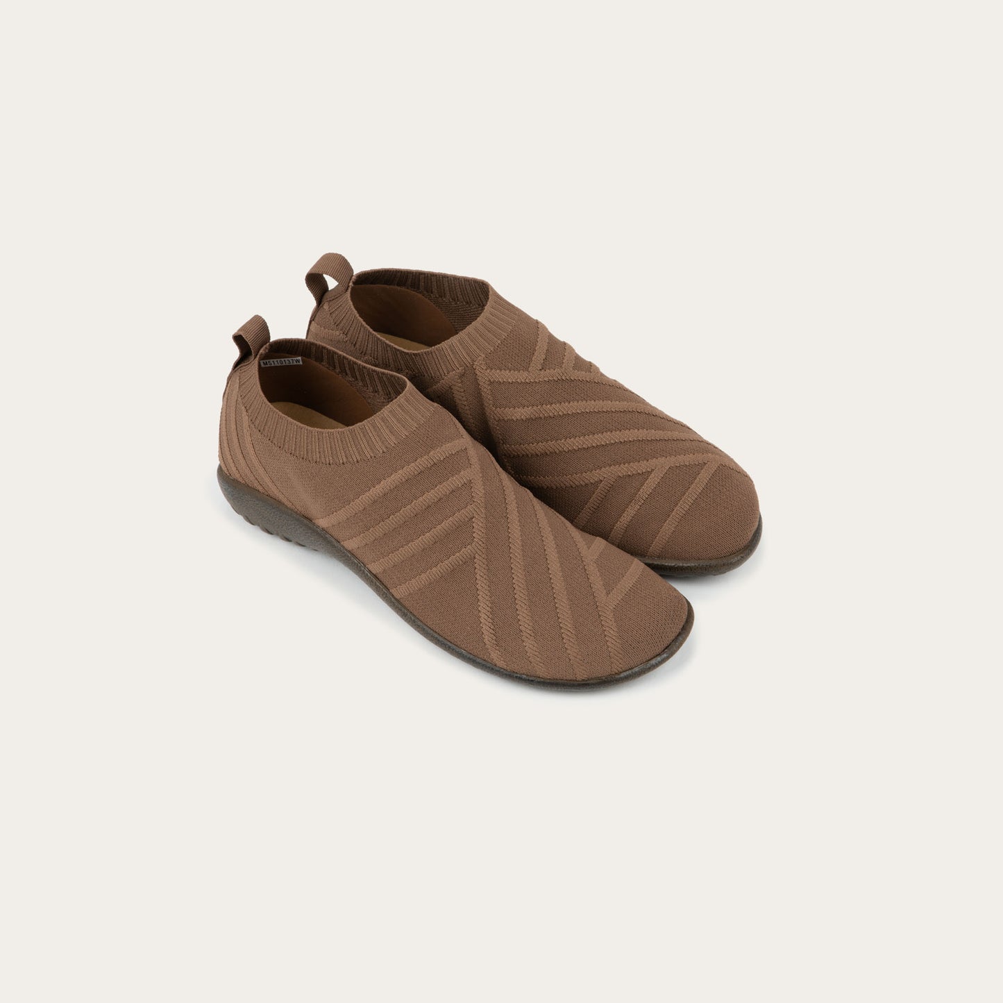 A pair of brown knit slip-on shoes on a gray sole