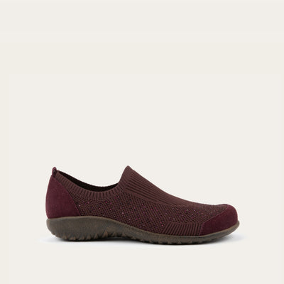 Profile view of a purple knit slip on shoe with rivet accents throughout.