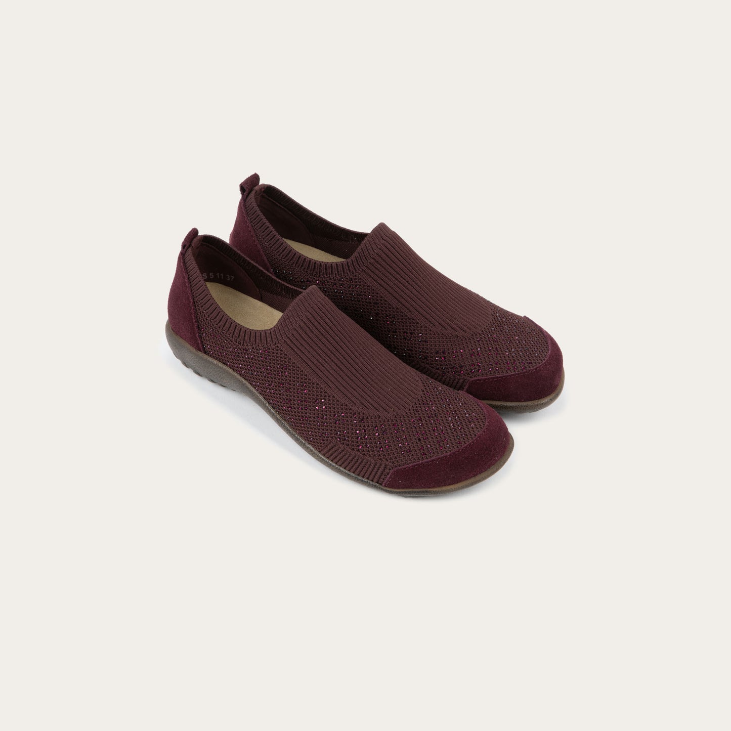 Pair of purple knit slip on shoes with rivet accents throughout.