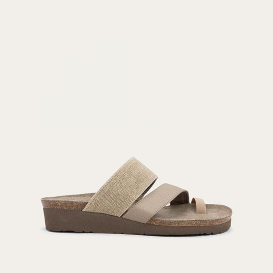 Profile view of beige, multi-strap, sling-back sandal with a cork footbed.